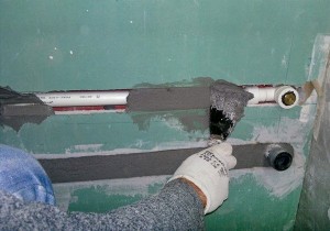 Прячем трубы в стену затем шпаклюем цементом