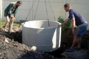 Процесс установки бетонных колец в выгребную яму